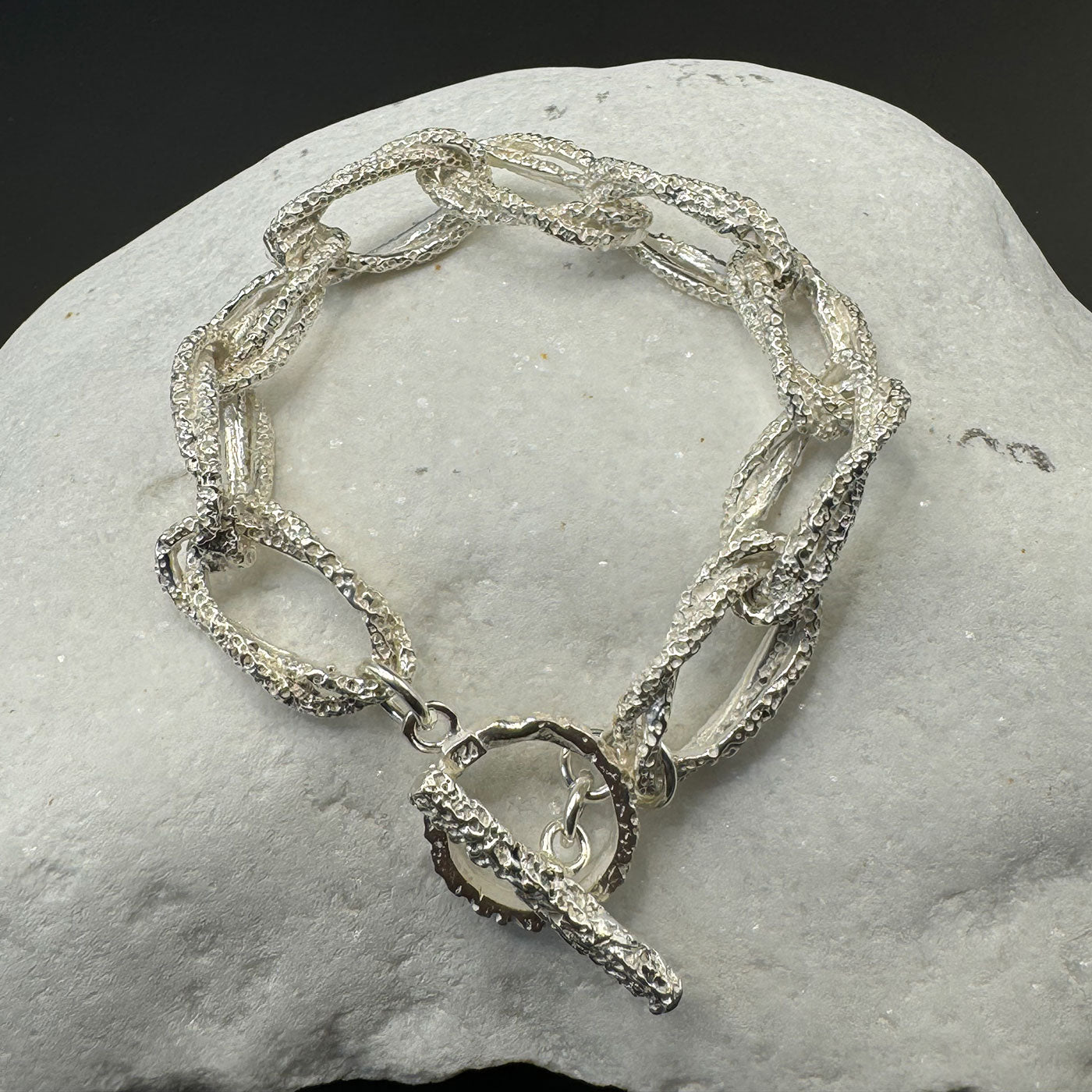 Silver chain bracelet on a stone surface