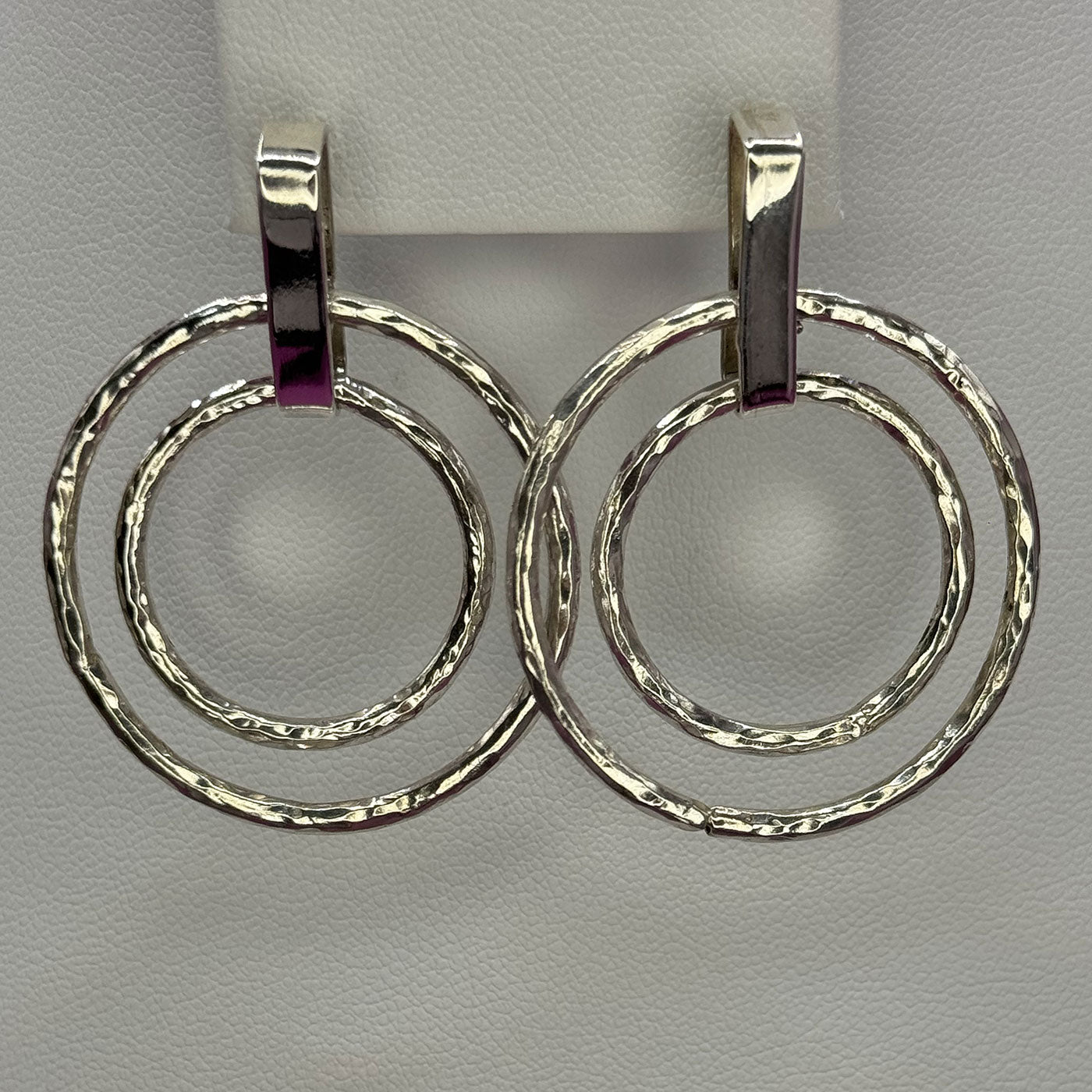 Pair of silver hoop earrings on a gray background